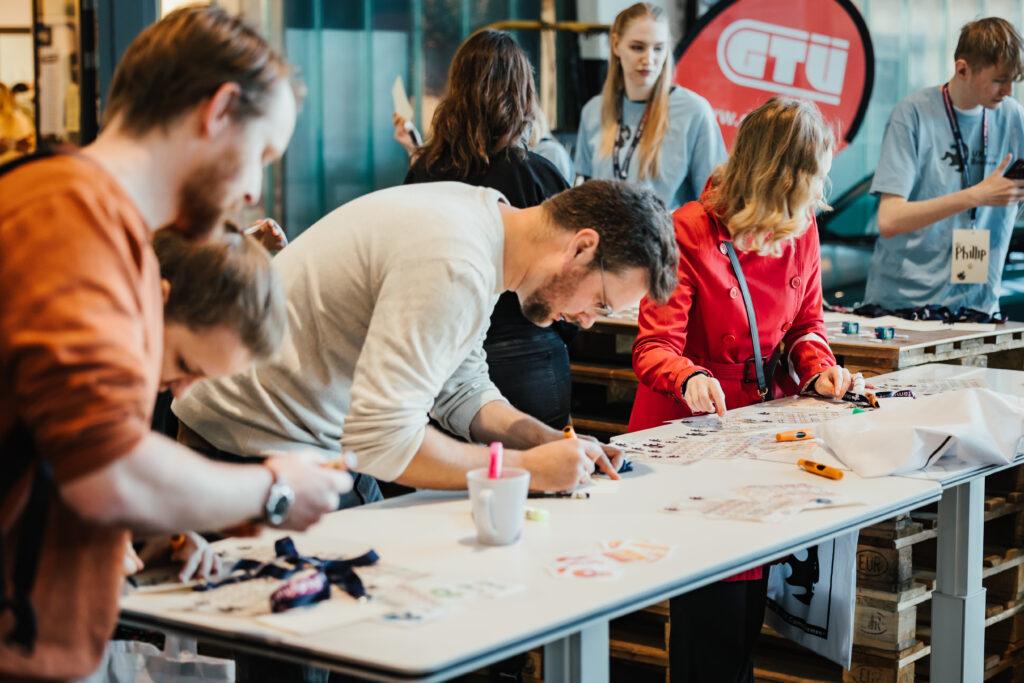 Check-In vom UX Camp Bremen. Teilnehmer:innen gestalten ihre eigenen Namensschilder.