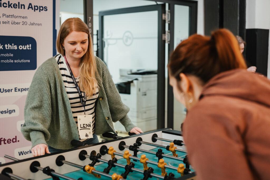 Zwei Teilnehmerinnen spielen am Kicker auf dem UXCamp Bremen